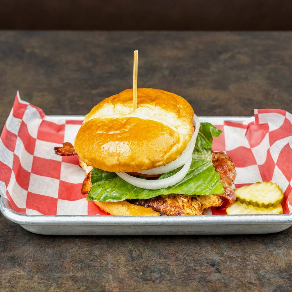 Grilled chicken sandwich with lettuce and onion.