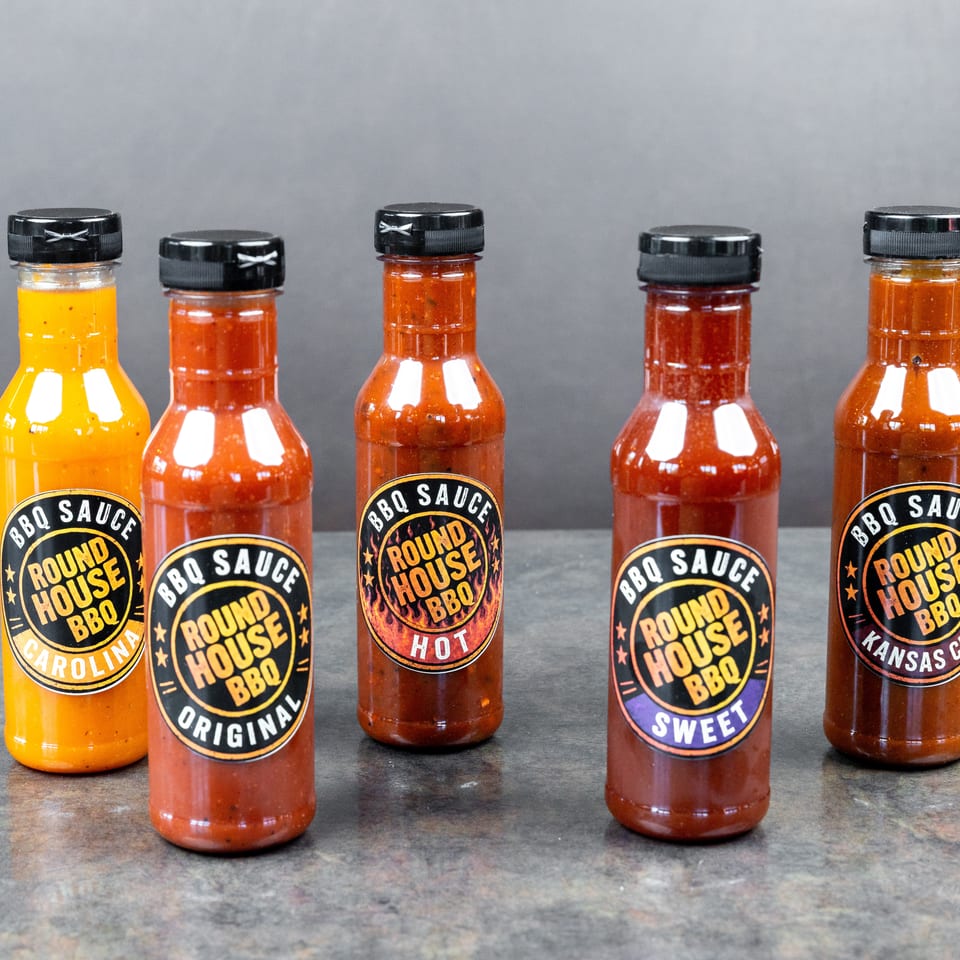 Five bottles of Round House BBQ sauce in Carolina, Original, Hot, Sweet, and Kansas City varieties.